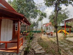 um jardim com uma pequena casa e um parque infantil em Homestay Lan Rung em Nghĩa Lộ