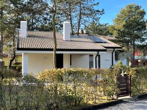 a white house with a red roof at Villaggio Azzurro - Ville in Bibione