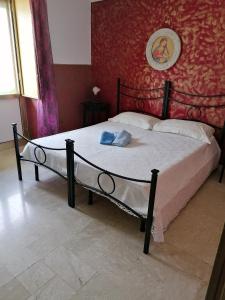 un letto in una camera da letto con parete rossa di B&b Mammannina a Carovigno
