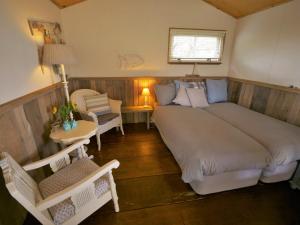 een slaapkamer met een groot bed en een tafel en stoelen bij Zoute Bries, in Natuurgebied en vlakbij het Strand in Callantsoog