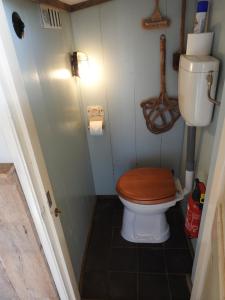 een kleine badkamer met een toilet en een houten toiletbril bij Zoute Bries, in Natuurgebied en vlakbij het Strand in Callantsoog