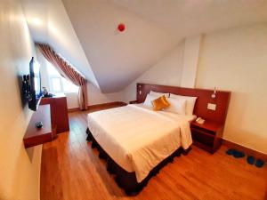 1 dormitorio con 1 cama grande en el ático en Rinny Hotel en Dalat