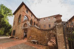 un vecchio edificio di mattoni con una panca davanti di Borgo San Lorenzo a Linari a San Rocco a Pilli