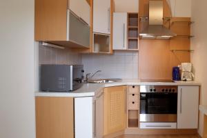 a kitchen with white cabinets and a stove top oven at Raiffeisenhof Appartements in Ehrenhausen