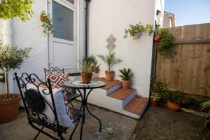 een kleine patio met een tafel en potplanten bij No.89 Stylish Ground Floor Apartment in Paignton