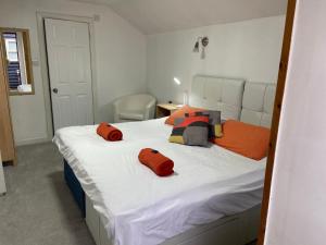 a bedroom with a bed with two pillows on it at Woodland Lodge in Hoddesdon