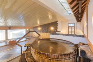 a large wooden tub in the middle of a room at Tabist Kinugawa Park Cottage in Nikko