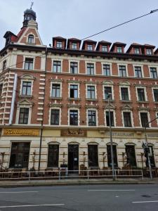 ein großes rotweißes Gebäude in einer Stadtstraße in der Unterkunft Hotel Merseburger Hof in Leipzig