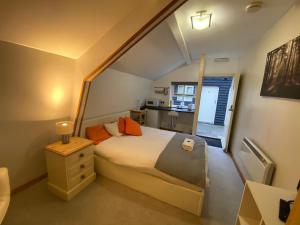 Dormitorio pequeño con cama y cocina pequeña en Woodland Lodge en Hoddesdon