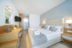 a hotel room with a bed and a television at Sunny Hotel Thassos in Chrysi Ammoudia