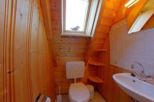 een badkamer met een toilet, een wastafel en een raam bij Strandvogt 2 MS6 in Dorum Neufeld