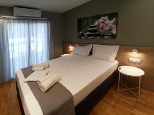 ein Schlafzimmer mit einem großen weißen Bett mit einem Stuhl in der Unterkunft Athens Sweet Home in Athen