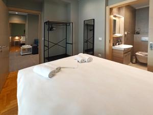 ein Badezimmer mit einem großen Bett mit zwei Handtüchern darauf in der Unterkunft Athens Sweet Home in Athen