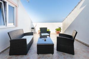 a patio with wicker chairs and a table at Apartments Albina in Lopar