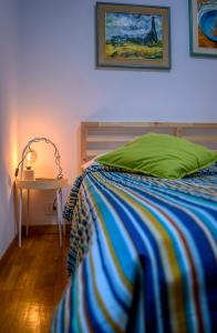 a bedroom with a bed with a green pillow and a table at Aduepassi in Ascoli Piceno