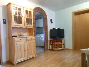 a living room with a television and a kitchen at Haus-Nordseemelodie-Wohnung-4 in Wittdün
