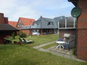 a backyard of a house with a table and chairs at Haus-Nordseemelodie-Wohnung-4 in Wittdün