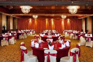 a banquet hall with red and white tables and chairs at Novotel Mumbai Juhu Beach in Mumbai