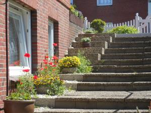 a set of stairs leading to a building with flowers at Ferienhaus-Heisser-Sand-Whg-5 in Wittdün