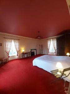 VerneuilLe Gîte de l Andarge的卧室里有一张白色的大床和两扇窗户