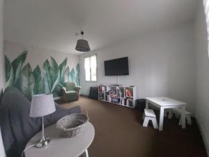 ein Wohnzimmer mit einem Sofa und einem Tisch in der Unterkunft Le Gîte de l Andarge in Verneuil
