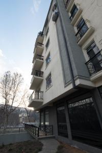 um edifício alto com janelas e uma varanda em Iren river side apartments em Tbilisi