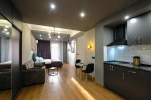 uma cozinha e uma sala de estar com um sofá e uma cama em Iren river side apartments em Tbilisi