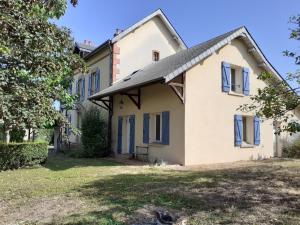 VerneuilLe Gîte de l Andarge的一座带蓝色窗户和庭院的古老房子