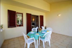 un tavolo con sedie bianche e una tovaglia blu di Villetta Turagri 22 a soli 300 m dalla spiaggia 10 posti letto a Costa Rei