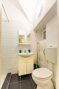 a bathroom with a white toilet and a sink at Piata Sfatului Central in Braşov