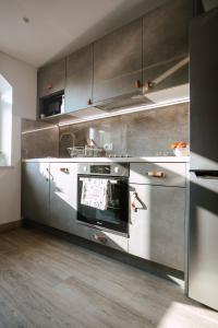 a kitchen with stainless steel cabinets and an oven at Unique city center Apartments Gran Fenice with free garage parking and roof terrace in one of the apartments in Rijeka +35 photos