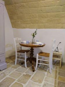 a table with two chairs and a table with a vase on it at IL Borgo Antico b&b in Altamura +45 photos