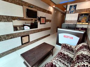 a waiting room with a bench and a television at Vrinda Apartments in Amritsar