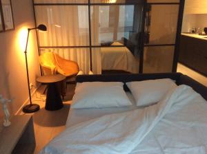 ein Schlafzimmer mit einem Bett mit weißer Bettwäsche und einer Lampe in der Unterkunft Ostend Central Residence in Ostende