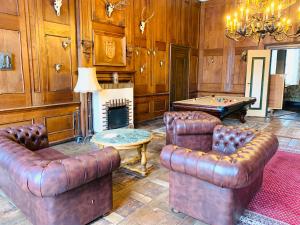 ein Wohnzimmer mit Ledermöbeln und einem Billardtisch in der Unterkunft Jagdschloß Walkenried in Walkenried