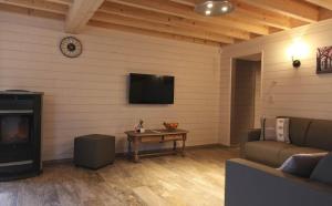 a living room with a tv and a couch and a table at Gîte proche du Pont de Belleheid et de Francorchamps in Jalhay