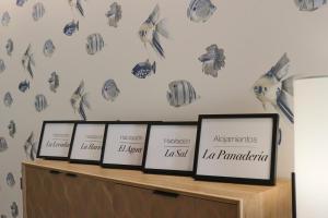 a row of framed frames on a shelf with birds on the wall at La Panadería in El Rompido