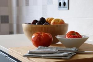 a bowl of fruit and a bowl of tomatoes on a cutting board at La Panadería in El Rompido