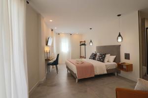 a bedroom with a bed and a table and a chair at La Panadería in El Rompido