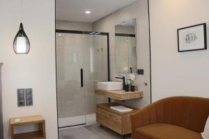 a bathroom with a sink and a glass shower at La Panadería in El Rompido