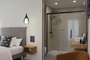 a bedroom with a bed and a glass shower at La Panadería in El Rompido
