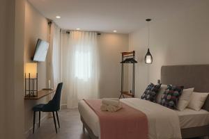 a bedroom with a bed and a desk and a chair at La Panadería in El Rompido