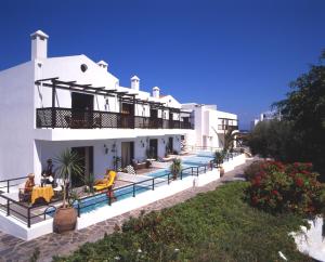 a white house with people sitting on the balcony at Hersonissos Maris in Hersonissos
