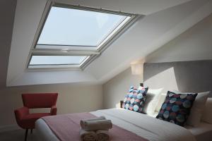 a bedroom with a skylight and a bed and a chair at La Panadería in El Rompido