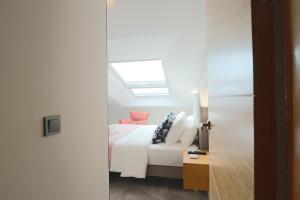 a bedroom with a white bed and a skylight at La Panadería in El Rompido