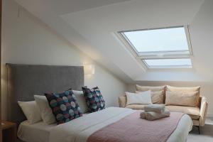 a bedroom with a bed and a couch with a skylight at La Panadería in El Rompido