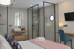 a bedroom with a shower and a bed and a chair at La Panadería in El Rompido