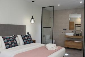 a bedroom with a large bed and a bathroom at La Panadería in El Rompido