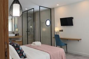 a room with a bed and a bathroom with a television at La Panadería in El Rompido