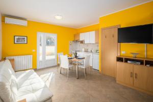 une cuisine avec des murs jaunes et une table avec des chaises dans l'établissement Apartment Gloria Premium, à Poreč